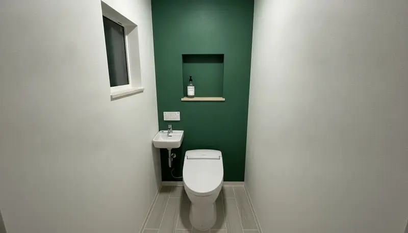 平屋のトイレを清潔感に。深いグリーンのアクセントが主役。